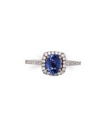 A SAPPHIRE AND DIAMOND RING HALO RING. THE CENTRAL SAPPHIRE IN A RAISED FOUR CLAW SETTING, APPROX