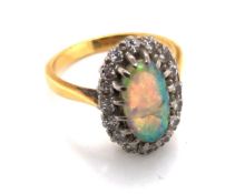 AN 18ct YELLOW GOLD ANTIQUE OPAL AND DIAMOND RING. THE OVAL OPAL IN A MULTI CLAW SETTING SURROUND BY