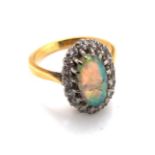 AN 18ct YELLOW GOLD ANTIQUE OPAL AND DIAMOND RING. THE OVAL OPAL IN A MULTI CLAW SETTING SURROUND BY