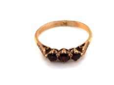 A VINTAGE THREE STONE GARNET RING, STAMPED 9ct AND ASSESSED AS 9ct YELLOW GOLD. FINGER SIZE P.