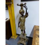 A CARVED STANDING FIGURE OF A BLACKAMOOR WEARING A GILT CLASSICAL TUNIC, HIS LEFT HAND RAISED TO