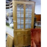 A 19TH CENTURY GLAZED PINE CORNER CUPBOARD, THE TOP WITH FOUR WHITE PAINTED SHELVES ABOVE A DRAWER A