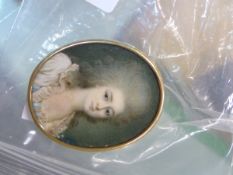 A PORTRAIT MINIATURE OF AN 18TH CENTURY LADY WITH GREY POWDERED HAIR, THE GILT OVAL FRAME WITH