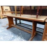 AN OAK THREE PLANK TOPPED REFECTORY TABLE ON SHAPED PANELS EACH NARROW END JOINED BY A STRETCHER