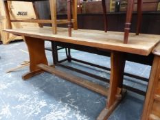 AN OAK THREE PLANK TOPPED REFECTORY TABLE ON SHAPED PANELS EACH NARROW END JOINED BY A STRETCHER