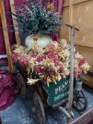 A HAND DRAWN CART CONTAINING DRIED FLOWERS IN A DOULTON JAR TO SELL VINEGAR AT A PENNY A PINT