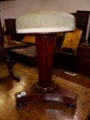 A VICTORIAN MAHOGANY PIANO STOOL ON HEXAGONAL COLUMN TAPERING TO A TRIPARTITE PLINTH AND BUN FEET