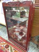 A CHINESE HARDWOOD WALL DISPLAY CABINET WITH A GLAZED DOOR OVER THE NETWORK OF NARROW SHELVES