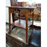 AN ART NOUVEAU MAHOGANY TWO TIER TABLE, THE PIERCED APRON BETWEEN SQUARE LEGS FLARING DOWN TO THE