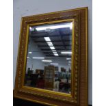A RECTANGULAR BEVELLED GLASS MIRROR IN TWO TONE GILT FRAME MOULDED WITH FOLIAGE AND BEADED BANDS. 56