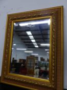 A RECTANGULAR BEVELLED GLASS MIRROR IN TWO TONE GILT FRAME MOULDED WITH FOLIAGE AND BEADED BANDS. 56