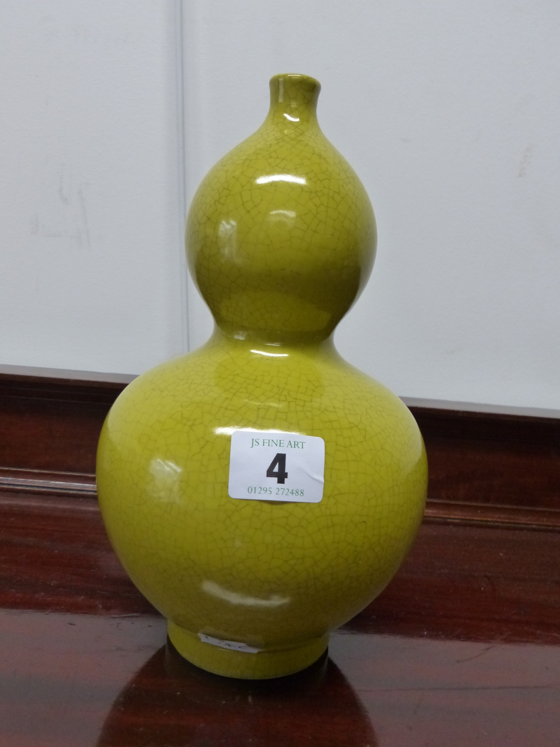 AN ORIENTAL DOUBLE GOURD VASE WITH YELLOW GLAZE.