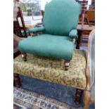 A GREEN DAMASK UPHOLSTERED VICTORIAN NURSING CHAIR ON BALUSTER LEGS TOGETHER WITH AN OTTOMAN STOOL