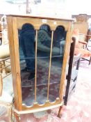 A GLAZED MAHOGANY CORNER CABINET, THE THREE PANELLED DOOR OVER THREE SHELVES AND CABRIOLE LEGS ON