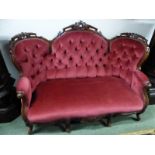 A VICTORIAN MAHOGANY BUTTON BACKED THREE SEAT SETTEE, THE TOP RAIL WITH THREE ROUND ARCHES CARVED