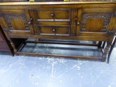 A BESPOKE OAK SIDEBOARD WITH CARVED DOORS FLANKING TWO DRAWERS ABOVE BALUSTER LEGS JOINED BY STRETCH