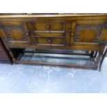 A BESPOKE OAK SIDEBOARD WITH CARVED DOORS FLANKING TWO DRAWERS ABOVE BALUSTER LEGS JOINED BY STRETCH