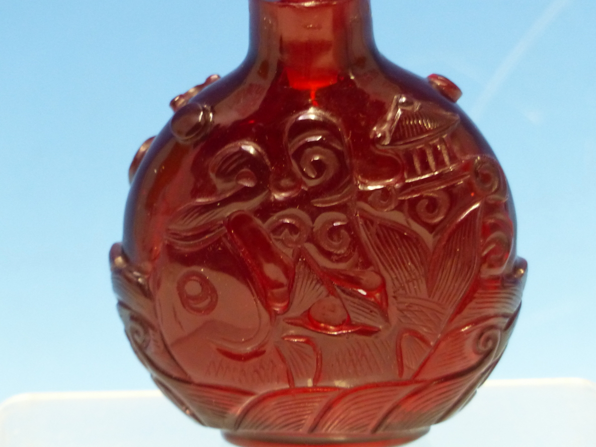 A CHINESE RUBY GLASS SNUFF BOTTLE WITH EUROPEAN STOPPER, EACH SIDE CARVED WITH A FISH ON ITS BACK - Bild 2 aus 6