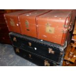 TWO VICTORIAN BLACK TRUNKS AND ANOTHER COVERED IN BROWN CANVAS