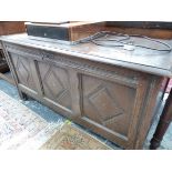 AN ANTIQUE OAK COFFER, THE THREE DIAMOND CENTRED PANELS TO THE FRONT ENCLOSED BY CHIP CARVED BANDS.