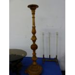 A BAROQUE STYLE WALNUT TORCHERE CARVED WITH FOLIAGE BANDS AND PIECRED BUN KNOP, THE CIRCULAR FOOT ON