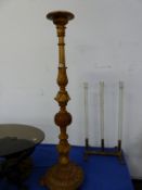 A BAROQUE STYLE WALNUT TORCHERE CARVED WITH FOLIAGE BANDS AND PIECRED BUN KNOP, THE CIRCULAR FOOT ON