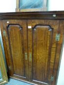 A GEORGIAN WALNUT CORNER CUPBOARD WITH ROUND ARCH FIELDED PANELLED DOORS. W 90 x H 110cms.