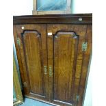 A GEORGIAN WALNUT CORNER CUPBOARD WITH ROUND ARCH FIELDED PANELLED DOORS. W 90 x H 110cms.