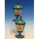 A PAIR OF ORMOLU MOUNTED SEVRES STYLE JEWELLED TURQUOISE GROUND COVERED GOBLETS PAINTED ON ONE