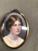 AN ANTIQUE MINIATURE PORTRAIT PAINTING OF A GIRL SIGNED JOHN MOSLEY 1910, WITH A BRASS FRAME.