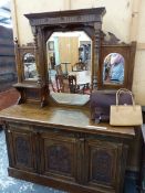 A LATE VICTORIAN MIRROR BACKED OAK SIDE BOARD CRESTED BY FIVE CARVED ROSETTES, THE BASE DOORS BELOW