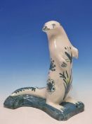 D T SHARP, RYE, A POTTERY FIGURE OF A SEAL PAINTED WITH SEA GREEN FLOWERS. H 30cms.