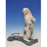 D T SHARP, RYE, A POTTERY FIGURE OF A SEAL PAINTED WITH SEA GREEN FLOWERS. H 30cms.