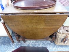 AN OAK OVAL FLAP TOP TABLE, THE BALUSTER LEGS JOINED BY STRETCHERS ABOVE THE BUN FEET. W 93 x D 60 x