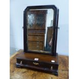 A MAHOGANY DRESSING TABLE MIRROR WITH A GILT FOLIATE SLIP AND SUPPORTED ON A THREE DRAWER BASE.