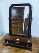 A MAHOGANY DRESSING TABLE MIRROR WITH A GILT FOLIATE SLIP AND SUPPORTED ON A THREE DRAWER BASE.