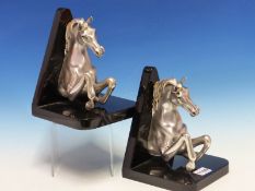 A PAIR OF OTTAVIANI SILVER PRANCING HORSE BOOKENDS, THEIR HALF BODIES BACKED BY BLACK TRIANGLES