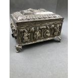 AN EASTERN SILVER HINGED BOX ON FOUR RAISED FOLIATE LEGS, THE BOX DECORATED WITH