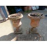 A PAIR OF COMPOSITE CLASSICAL STYLE GARDEN URNS.