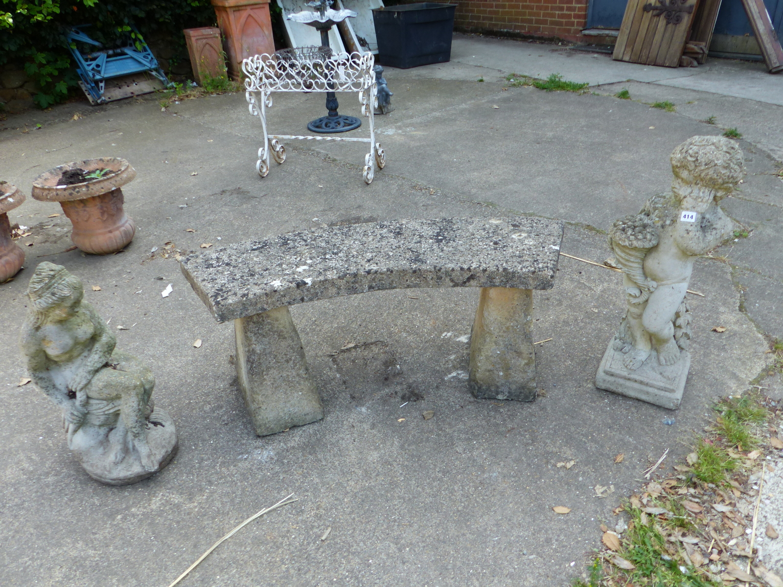 A COMPOSITE PEDESTAL GARDEN SEAT AND TWO GARDEN FIGURES.