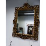 A FLORENTINE RECTANGULAR MIRROR IN FOLIATE PIERCED GILT FRAME, THE SIDES CENTRED BY SHELLS, THE