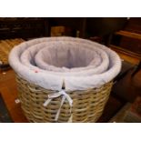 A GRADED SET OF THREE MAUVE TEXTILE LINED CYLINDRICAL BASKETS