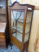 AN EDWRADIAN GLAZED MAHOGANY DISPLAY CABINET, THE SERPENTINE TOP AND DOOR BASE WITH PAINTED MARQUETR