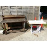 A WORKBENCH AND A SMALL GARDEN TABLE WITH CAST IRON SINGER BASE.