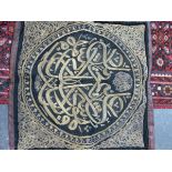 AN ISLAMIC ROUNDEL WORKED IN GOLD THREAD ON A BLACK SILK GROUND WITHIN FOLIATE SPANDRELS. 86 x