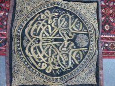 AN ISLAMIC ROUNDEL WORKED IN GOLD THREAD ON A BLACK SILK GROUND WITHIN FOLIATE SPANDRELS. 86 x