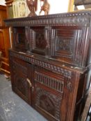 AN ANTIQUE OAK COURT CUPBOARD A GUILLOCHE BAND CARVED OVER TWO DOORS RECESSED ABOVE TWO FURTHER DOO