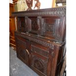 AN ANTIQUE OAK COURT CUPBOARD A GUILLOCHE BAND CARVED OVER TWO DOORS RECESSED ABOVE TWO FURTHER DOO