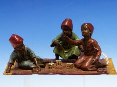 AN AUSTRIAN BERGMAN COLD PAINTED BRONZE GROUP OF THREE FEZ WEARING BOYS PLAYING DICE ON A