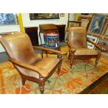 A PAIR OF LEATHER UPHOLSTERED TEAK COLONIAL TEA PLANTATION CHAIRS, THE FLAT ARMS WITH SWING OUT UNDE